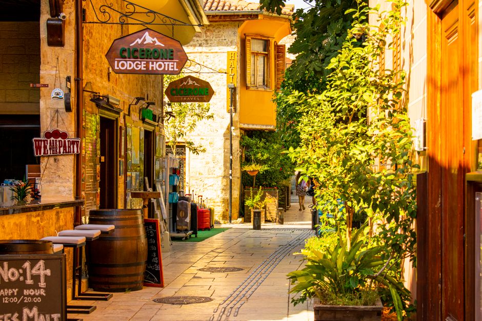 Explore a picturesque narrow street in Antalya, Türkiye, lined with cafes and boutiques.