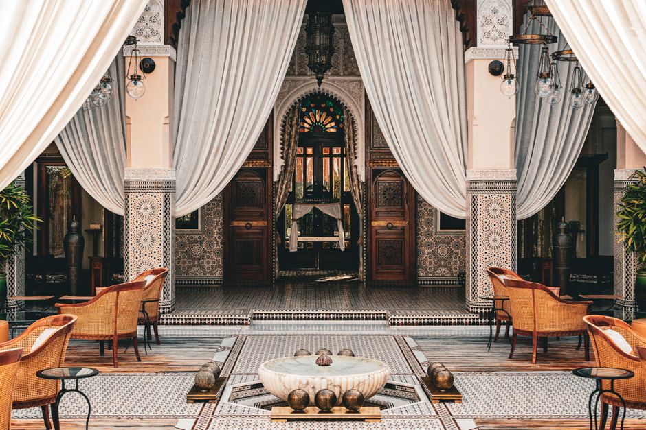 Beautiful Moroccan courtyard in Marrakesh with intricate tile work and elegant drapery.