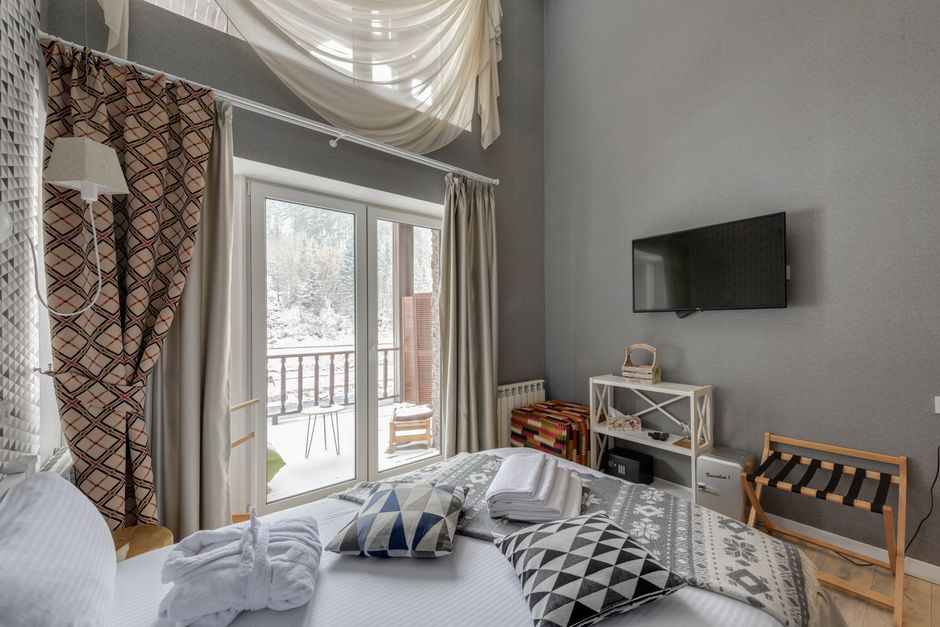 Elegant bedroom with large windows offering a snowy outdoor view.