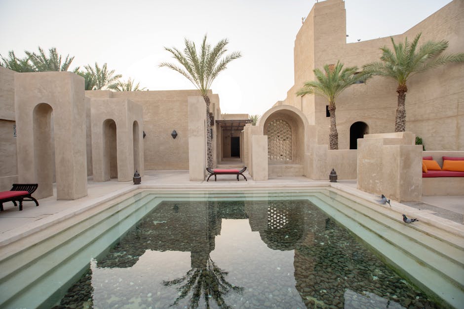 Experience serene luxury at a Dubai resort with traditional architecture and tranquil pool.