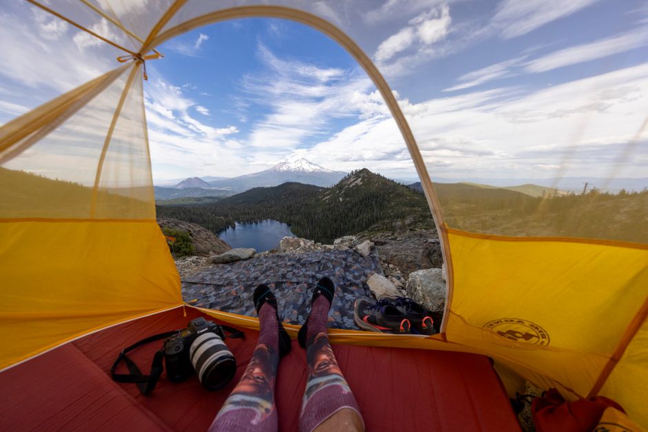 Wide-angle view of a mountain from a tent, showcasing outdoor adventure and serene landscape.