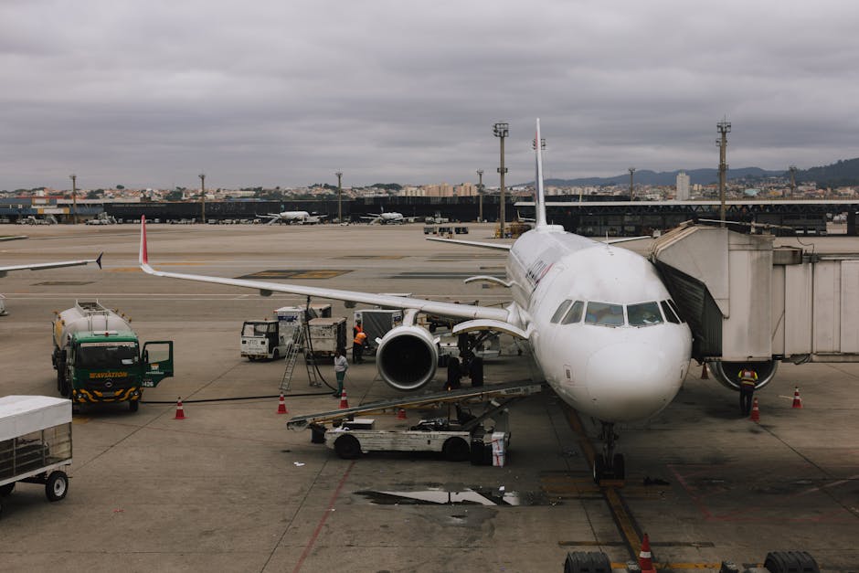 Airplane being prepared at São Paulo airport with jet bridge and ground crew.