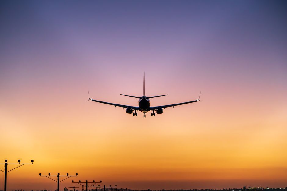 Silhouette of an airplane landing with a stunning sunset sky in Ontario, California.