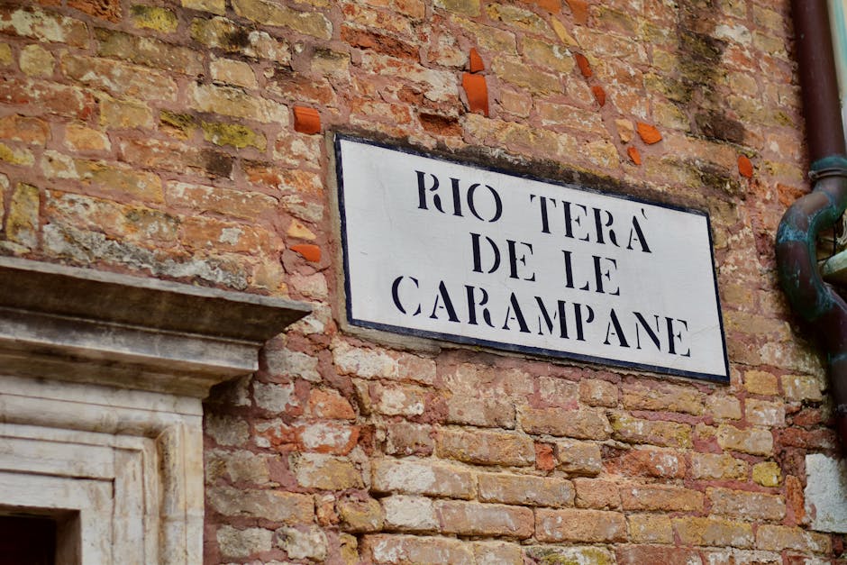 A vintage street sign on a brick wall in Venice's Rio Terà de le Carampane area.