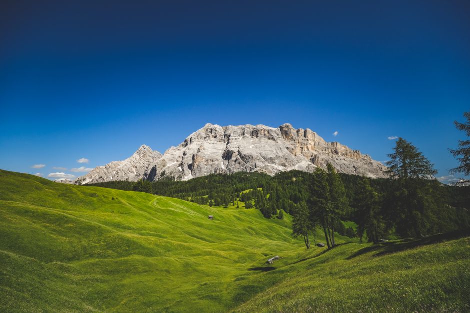Breathtaking view of mountains and green meadows under a clear blue sky.