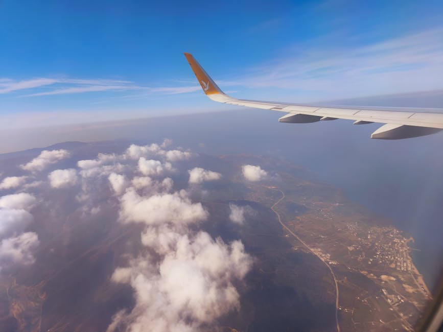 Stunning aerial view of a coastline and clouds captured from airplane during daylight.