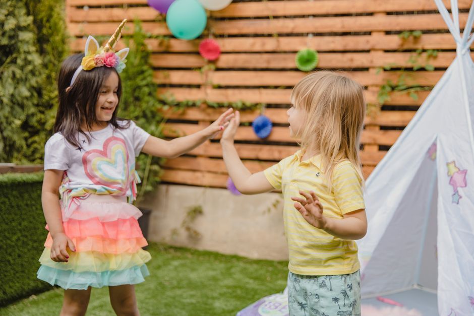 Children enjoy a vibrant outdoor birthday party with balloons and playful decor.