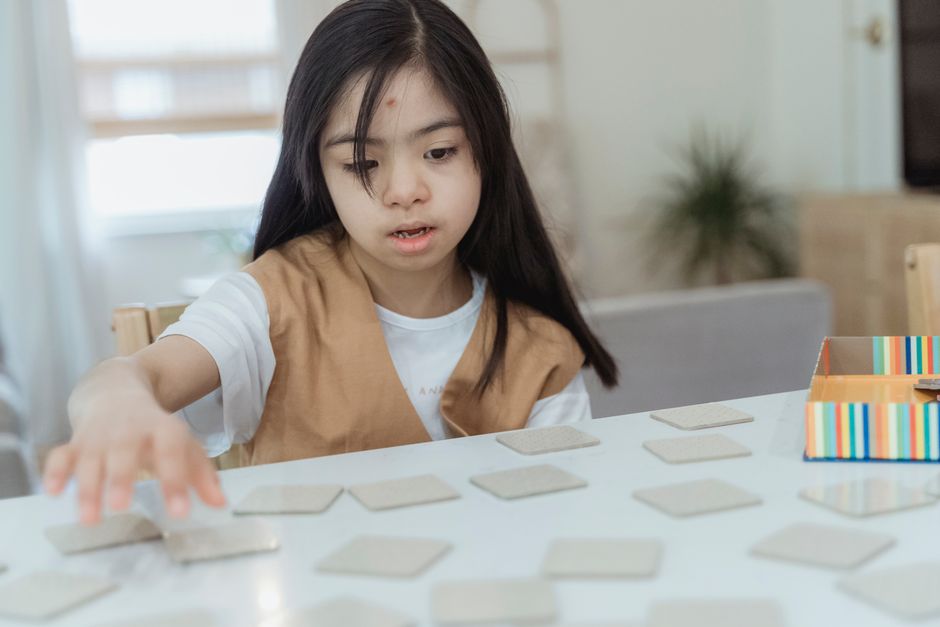 Young girl enjoying a memory card game at home, focused on the cards.