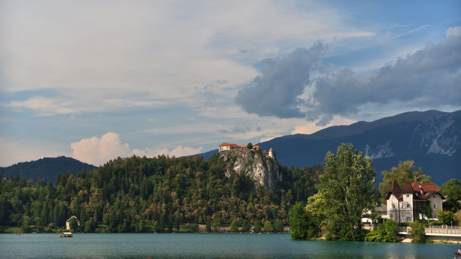 Captivating view of Bled Castle atop a rocky hill overlooking Lake Bled in Slovenia.
