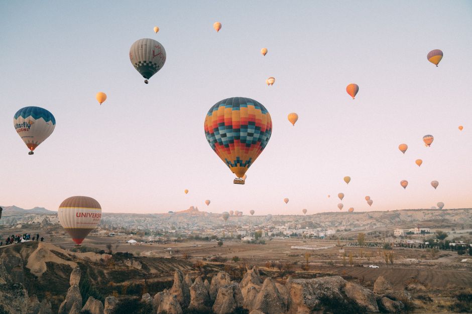 A stunning display of hot air balloons soaring over Cappadocia's unique landscape at dawn.