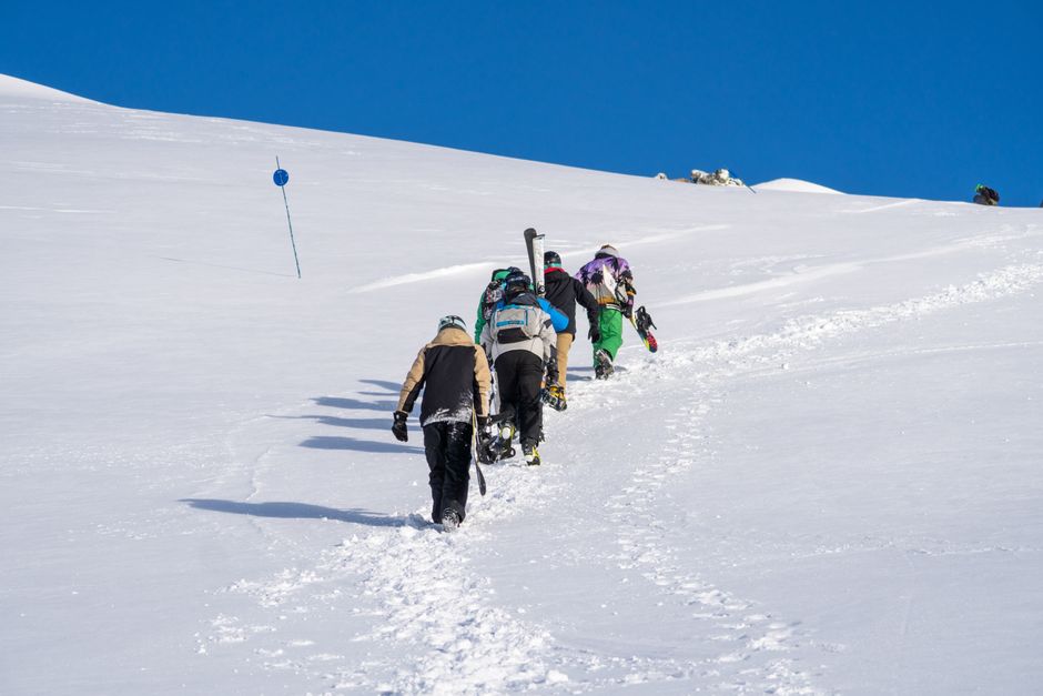 Group of adventurers hiking snowy slopes in Bariloche, Argentina, a vibrant winter scene.