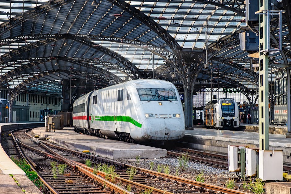 High-speed trains at a busy European train station under an architectural roof.
