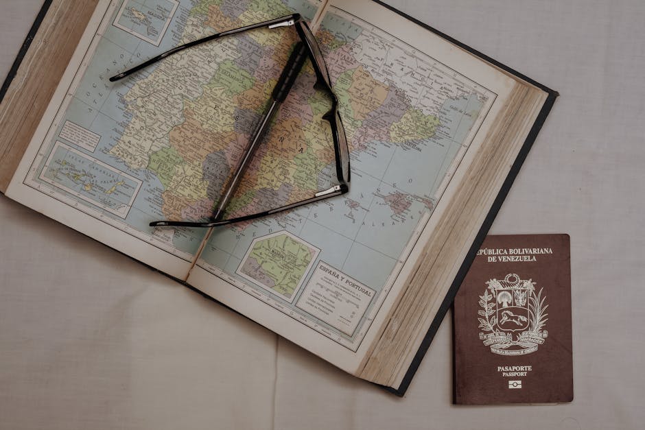 A vintage map of Spain with eyeglasses and a Venezuelan passport, symbolizing travel planning.