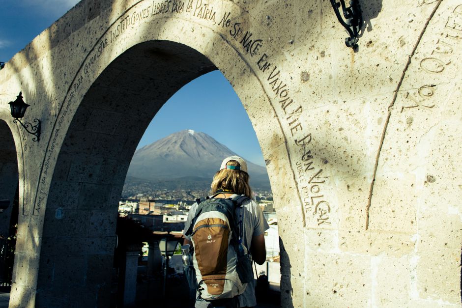 A traveler gazes at the Misti volcano from under the iconic Yanahuara Arch in Arequipa, Peru.